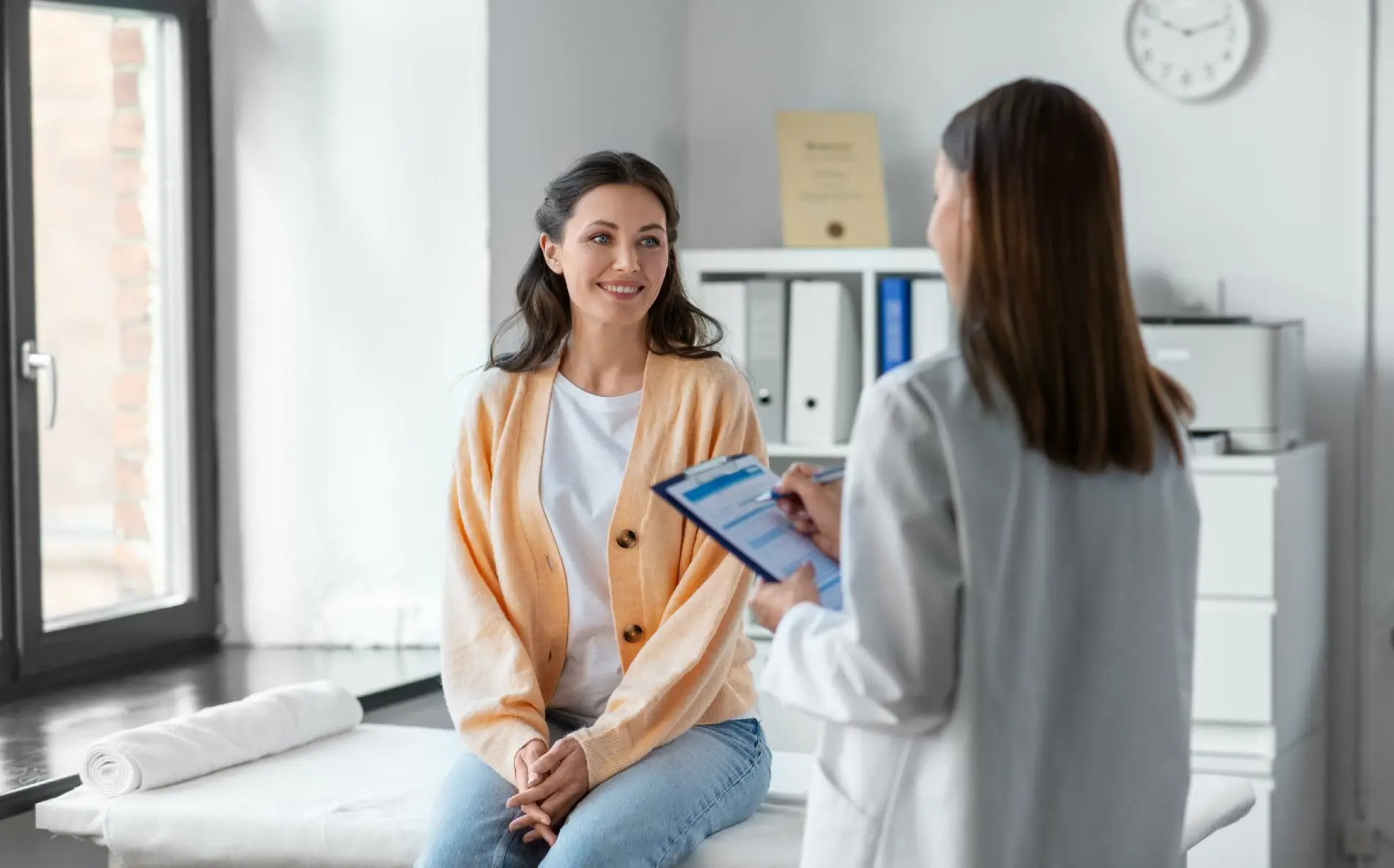 Medicine, healthcare and people concept - Female doctor with clipboard talking to smiling woman patient at hospital | Citidrips in Wilmington, DE